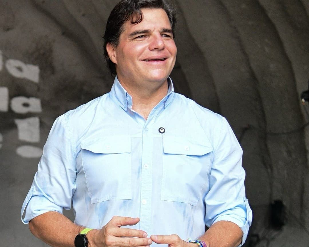 Alejandro Arbeláez A. conversa al aire libre, con las manos juntas