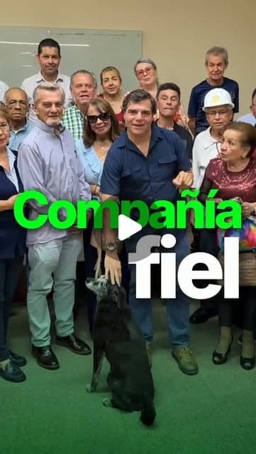 Alejandro Arbeláez A. posa con un grupo de personas en un salón; texto «Compañía fiel»
